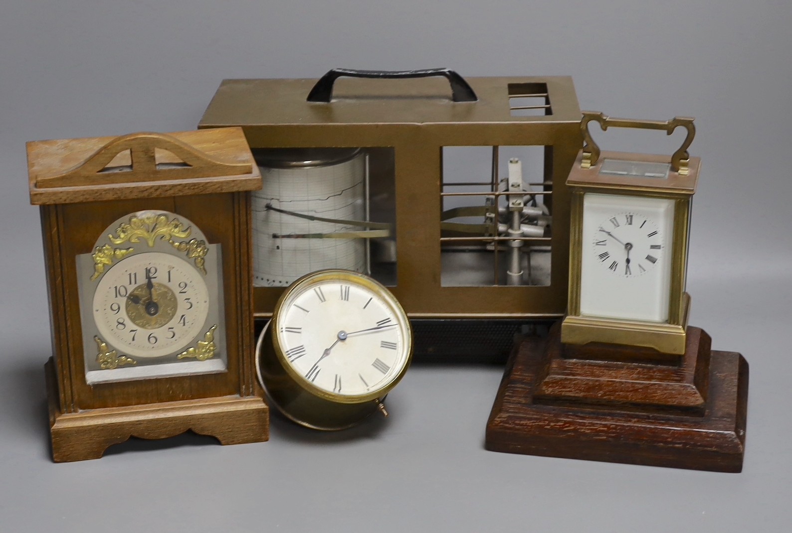 A barograph and three various time pieces including a carriage timepiece, a walnut bracket timepiece and a brass drum timepiece